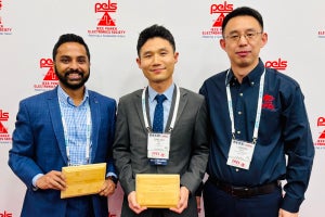 Three men holding their awards 